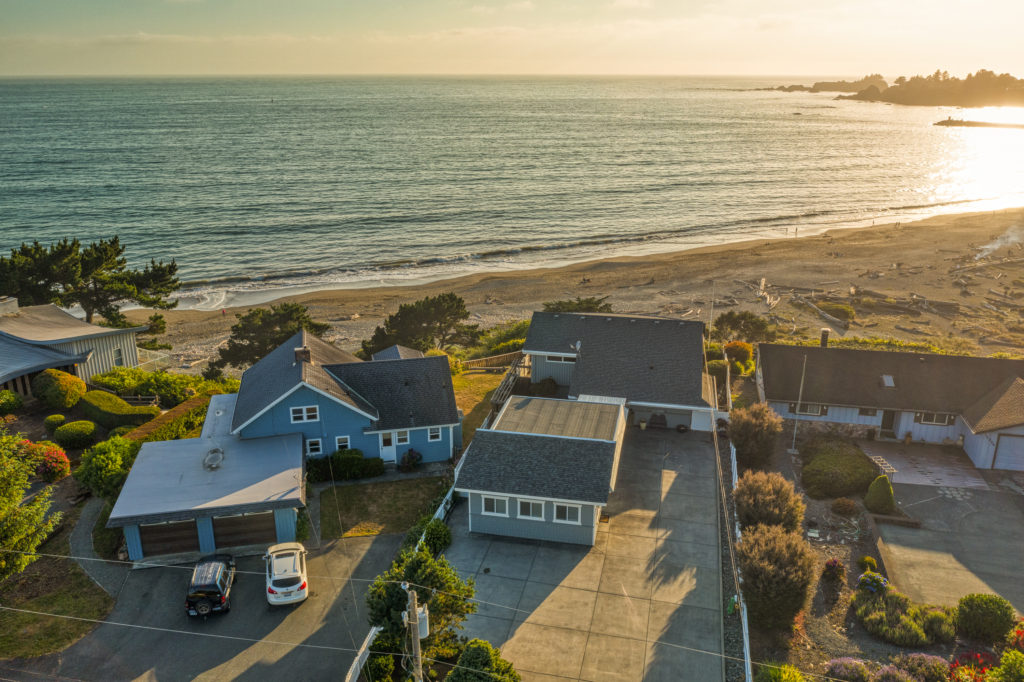Aerial biew of Day Dreamin' sitting right next to the ocean in a pleasant coastal neighborhood
