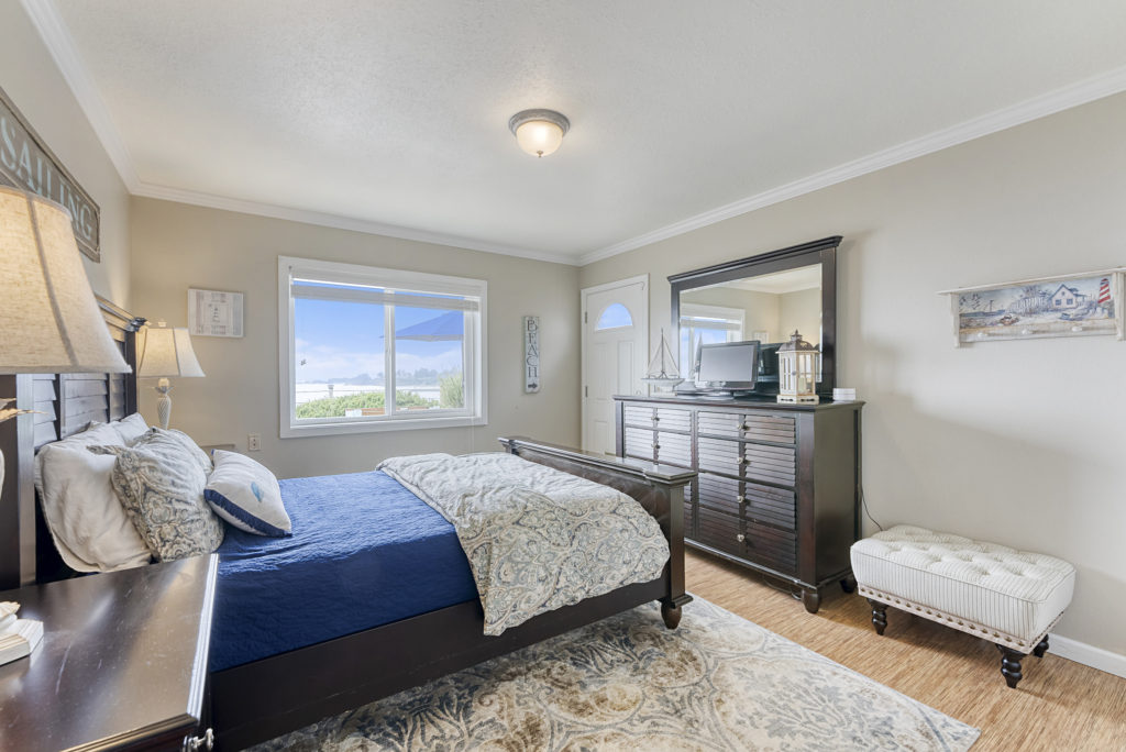 Another bedroom at Day Dreamin' - wood flooring, upscale furnishings, and large seaview window