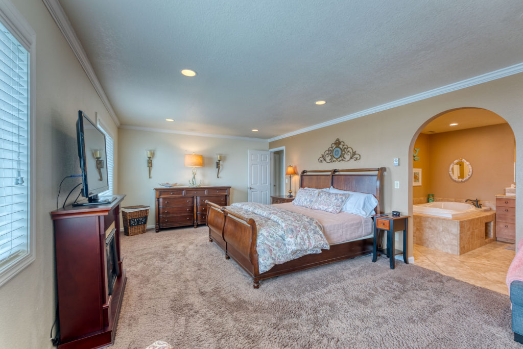 A photo of the master bedroom at Day Dreamin'. Carpet, upscale furnishings including sleigh bed, archway to spectacular master bathroom.