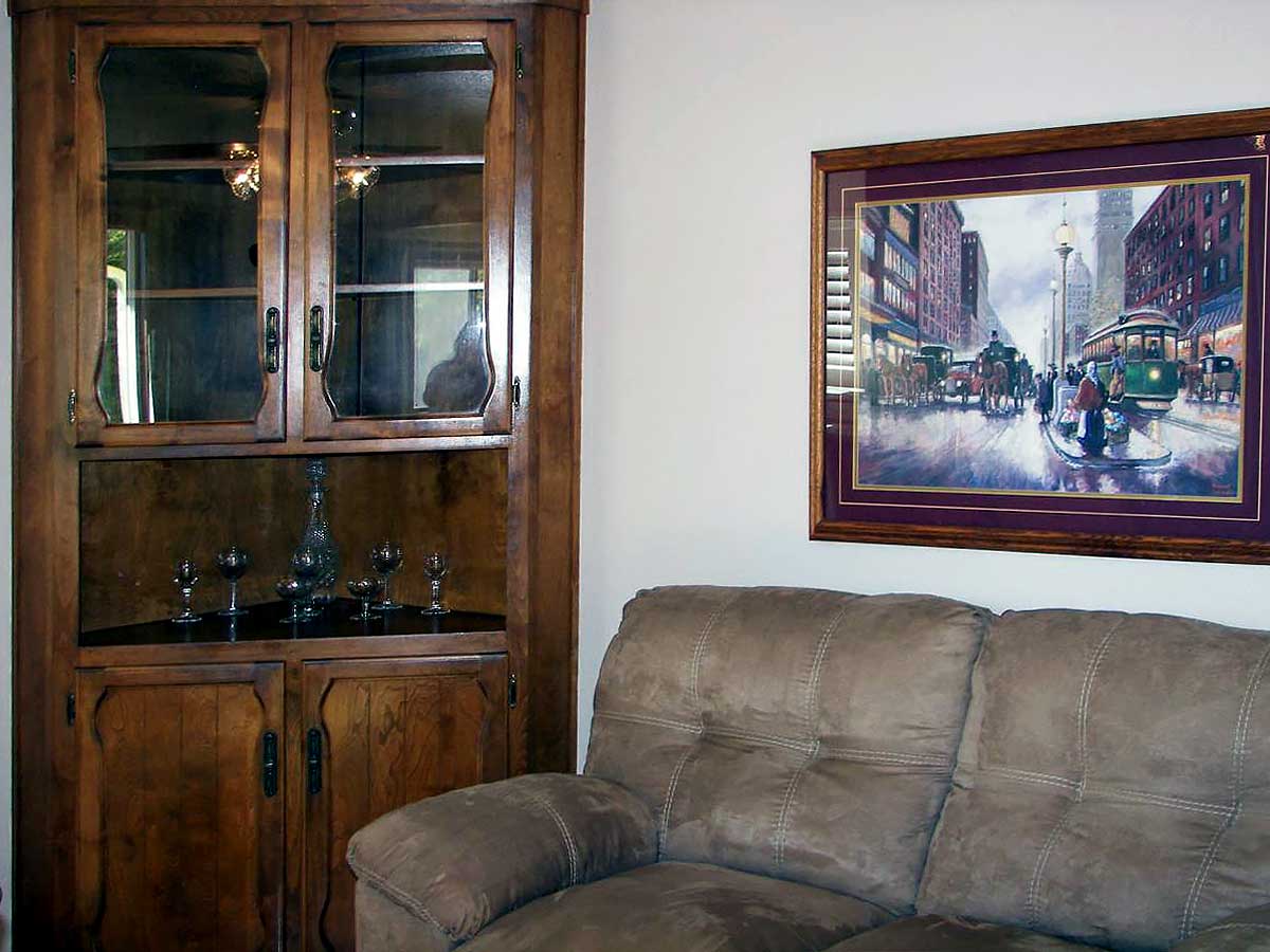 Photo of Thomas Kincaid art, sofa, and corner curio cabinet at Brookings Serenity