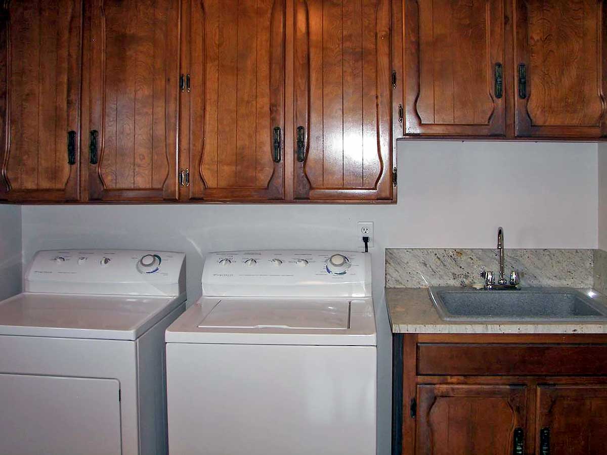 Photo of washer, dryer, sink and cabinets in laundry room in Brookings Serenity