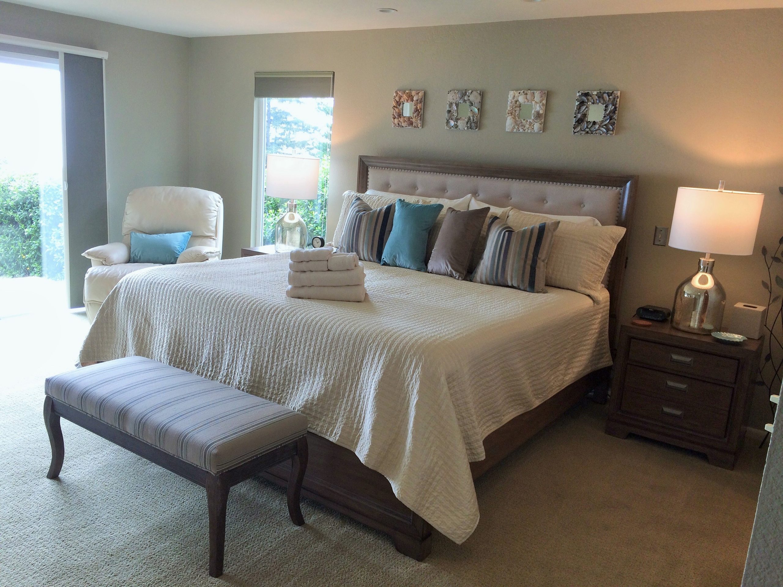 A bedroom at Pacific Edge with multiple windows and upscale furnishings at Pacific Edge