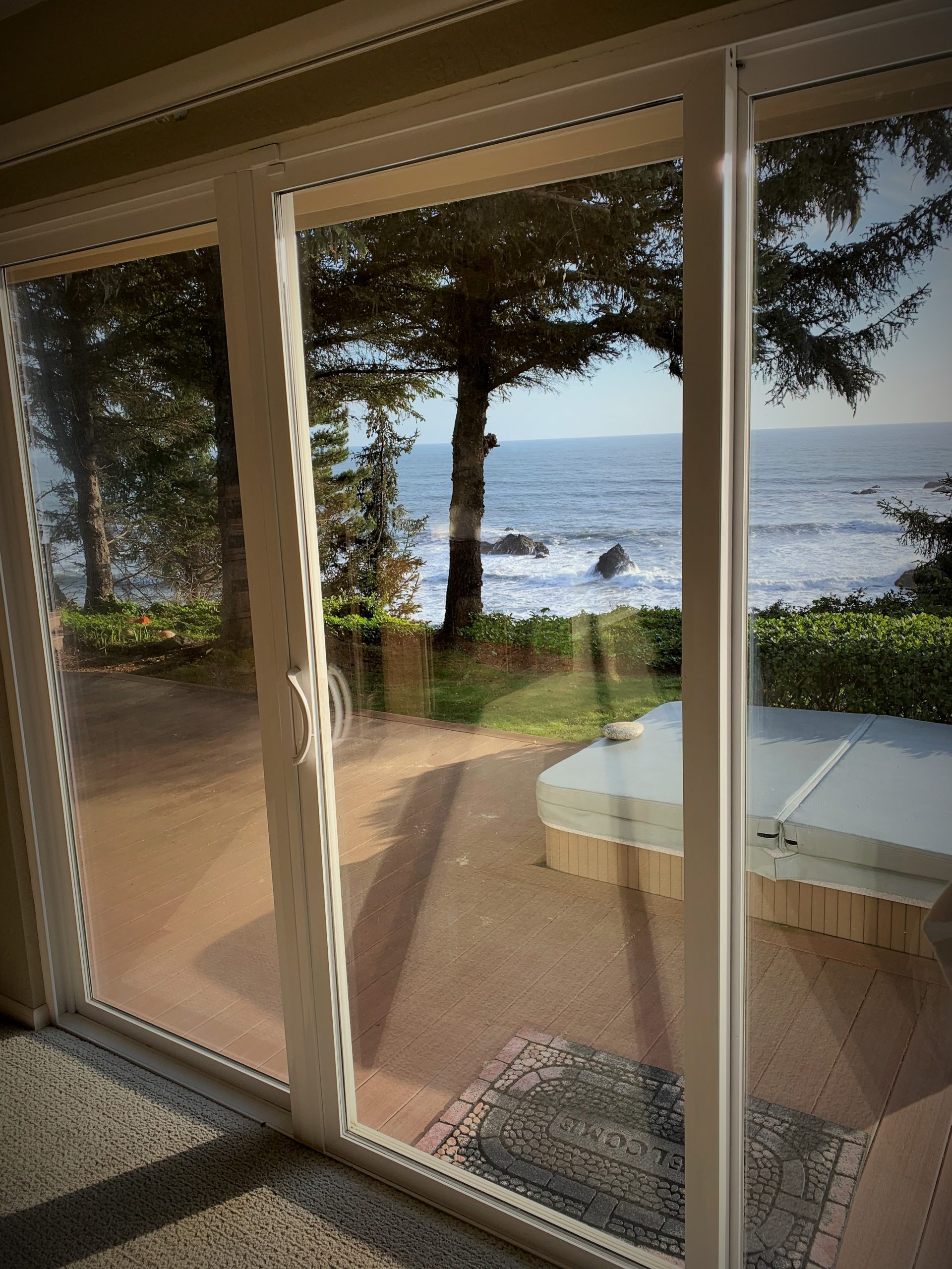 Photo of sliding glass door opening to deck with hot tub at Pacific Edge