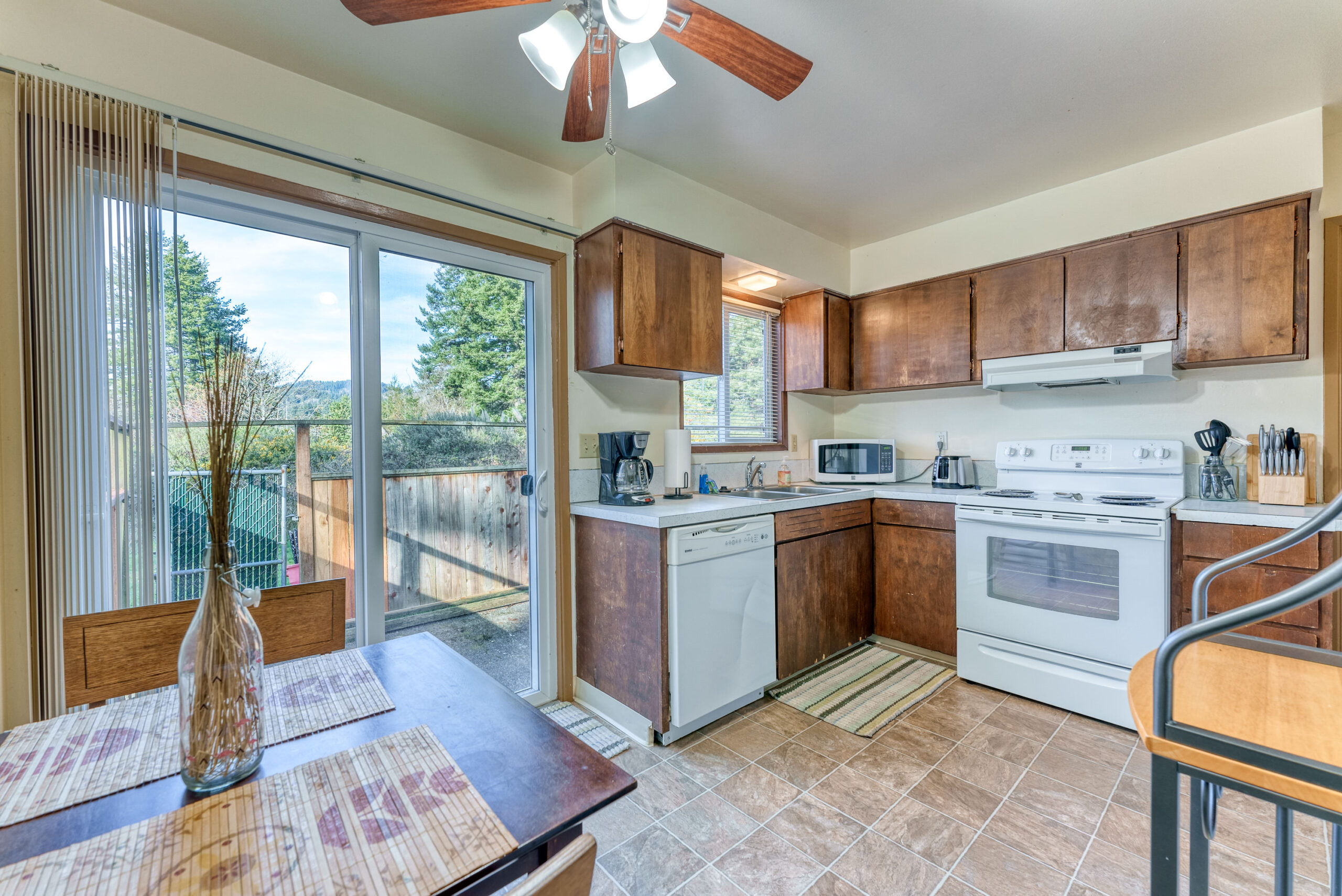 Bright kitchen with sliding glass door stepping outside to the fresh air of Brookings Oregon