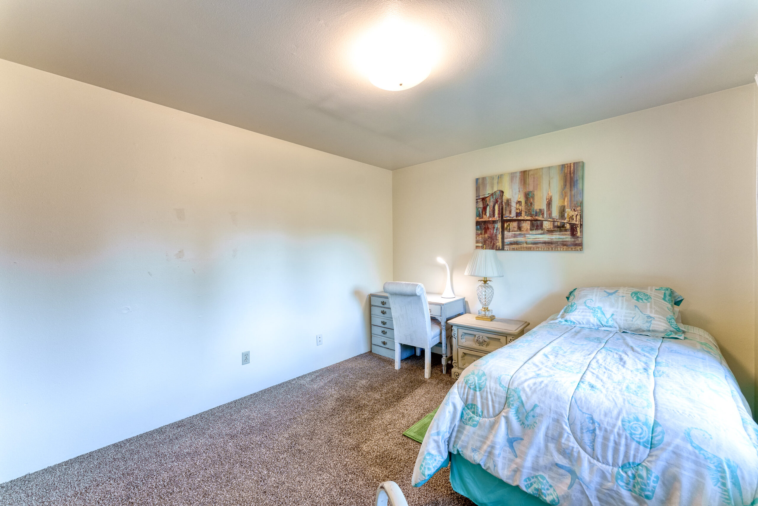 2nd Bedroom at Coastal Cozy Townhome featuring Twin bed, desk and rocking chair