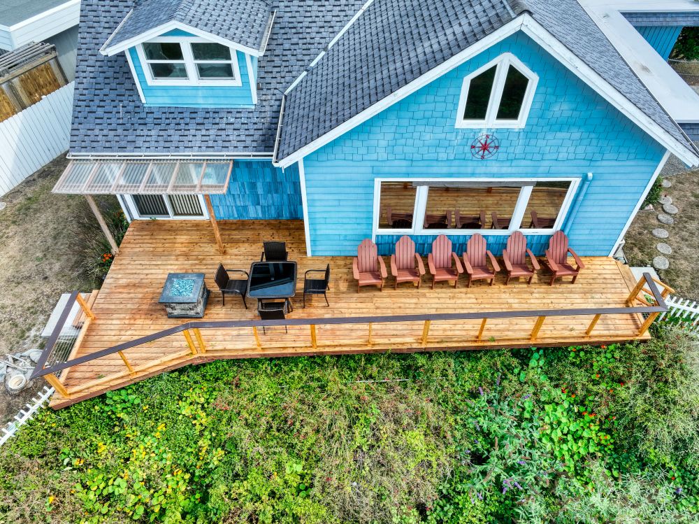 Photo of oceanside deck, table, firepit & deck chairs at Sunset Cabin